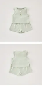Vista dettagliata del top estivo a costine verde menta e dei pantaloncini per bambina.
