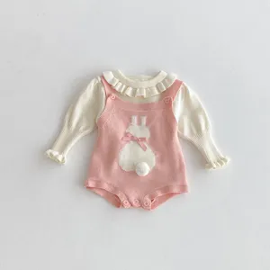 Süßes gestricktes Baby Strampler Detail mit Hasenmuster und Puschelschwanz für Herbst.