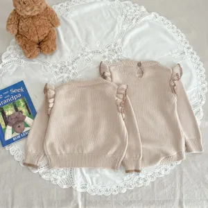 Beige Babypullover mit Rüschen an den Schultern, weiche Strickware Detailaufnahme für Babys.