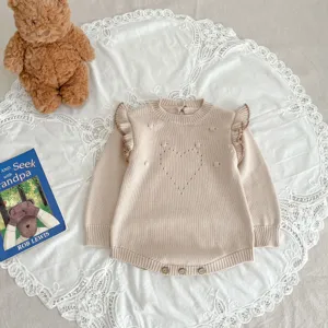 Baby Strick-Romper Detail, mit süßen Rüschen, Lochmuster Herz und praktischen Knöpfen unten.