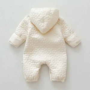 Vista detallada del cómodo mameluco acolchado beige para bebé con capucha, ropa de invierno.