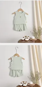 Dettaglio set top smanicato e pantaloncini estivi in cotone a costine per neonati, verde chiaro.