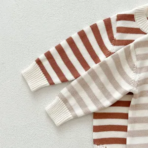 Nahaufnahme von gestrickten Baby-Strampler-Pullovern mit weicher Textur und feinem Strick.