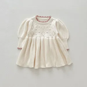 Detailed view of baby girl knit dress, diamond hollow pattern and cute puff sleeves.