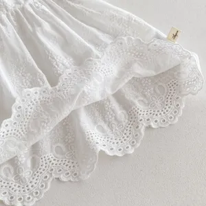 Baby girl white lace cotton dress detail, delicate embroidery hem, soft infant apparel.