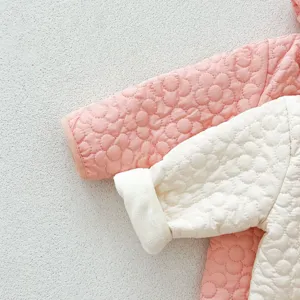 Detalle en primer plano del mameluco acolchado para bebé con suave patrón floral y forro cálido.