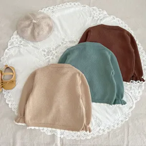 Detailed view of cute baby knit cardigan sweater in multi colors with cute edge and soft fabric.