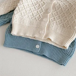 Infant baby knitted cardigan sweater detail view, soft cotton yarn material with buttons.