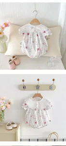 Cute baby girl summer short-sleeve romper with delicate lace collar and soft pink print.