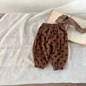 Pantaloni invernali spessi in velluto a coste per bambini con pois, dettaglio abbigliamento caldo.