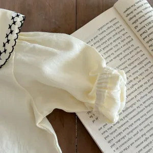 Säugling Baby Mädchen Oberteil Detail, Baumwollstoff mit besticktem Kragen und Ärmelbündchen.
