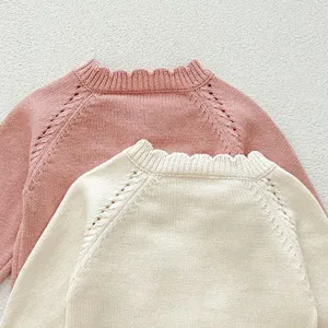 Baby knit sweater detail, cute pink and beige cotton yarn raglan sleeve pullover top.