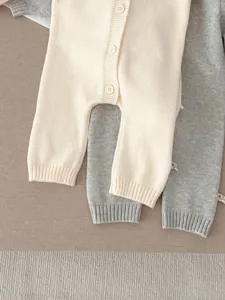 Vista detallada de mameluco tejido para bebé, ropa cómoda para recién nacidos.