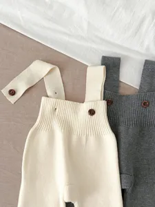 Infant knit strap pants and adorable baby overalls detail, soft autumn baby clothing style.