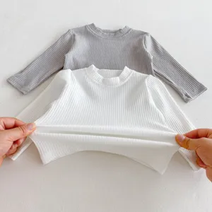 Detailansicht der Stoffdehnung von Babys geripptem Langarmshirt, weiches Baumwoll-Oberteil.