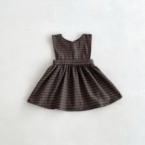 Detailed view of the brown plaid baby girl sleeveless dress, featuring a cute ruffled hemline.