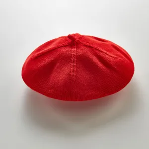 Detail view of the red knitted baby beret, showing clear texture and cute style for infants.