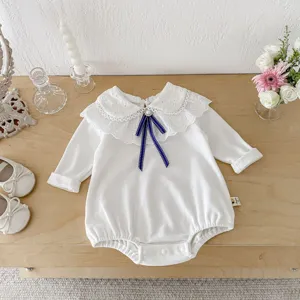 Infant baby girl long sleeve white bodysuit with lace collar and blue bow detail detail shot.