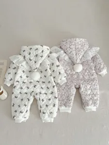 Detalle de mameluco acolchado de invierno para bebé con lazo, cuello de encaje y pompón.