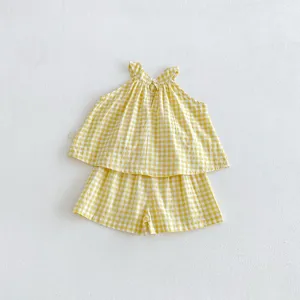 Grazioso set estivo per bambina piccola con top halter a quadri gialli e pantaloncini.