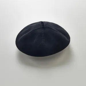 Infant black knitted beret detail shot, showcasing the soft fabric and cute top loop design.