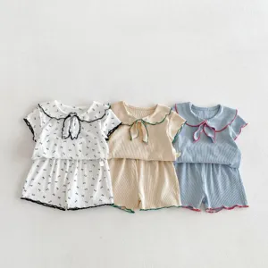 Dettaglio abbigliamento neonato estate, colletto alla marinara, fiocchi, set elastico.