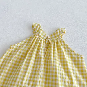 Dettaglio top halter bimba a quadri gialli, grazioso abbigliamento estivo neonata primo piano.