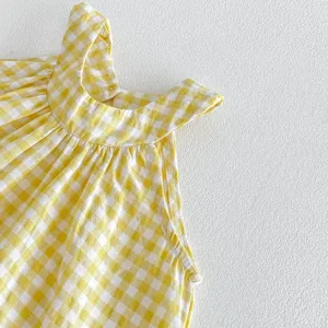Dettaglio top halter a quadri gialli per bambina piccola abbigliamento estivo smanicato primo piano.