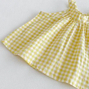 Primo piano dei dettagli del tessuto del top senza maniche con motivo vichy giallo bianco.