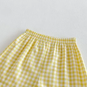 Primo piano dettaglio pantaloncini quadri gialli bianchi vita elastica stile estivo