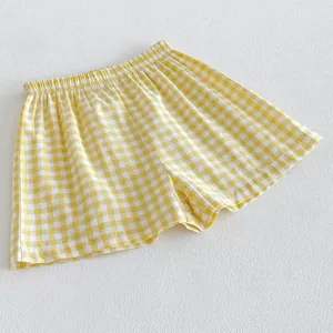 Primo piano dettagliato dei pantaloncini casual per bambini con quadri vichy gialli e bianchi.