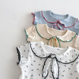 Dettaglio t-shirt manica corta a costine per neonata, colletto con volant e fiocco.
