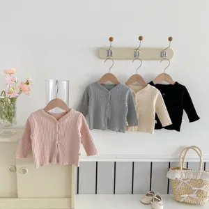 Gros plan sur les détails du gilet de bébé en tricot côtelé uni avec boutons et texture