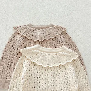 Baby knit sweater detail showing scalloped collar and hollow-out pattern close-up.