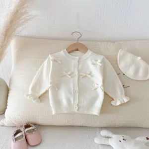 Detail view of baby girl bow knit cardigan, off-white sweet sweater top for infants and toddlers.