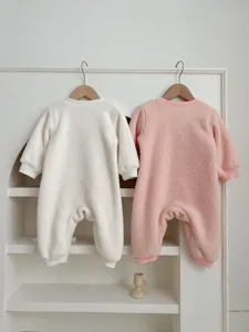 Detailed view of winter fleece baby romper hanging on rack, soft plush fabric, warm infant clothing.