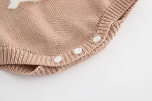 Detailed view of the baby knitted romper bottom buttons, showing soft cotton fabric and fine texture.
