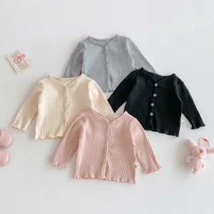 Vue détaillée du gilet en tricot pour bébé avec texture côtelée, boutons simples et tissu doux.