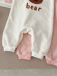 Detailed view of fluffy baby fleece romper with cute bear graphic and soft warm fabric.