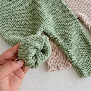 Dettaglio tutina neonato in maglia a coste, cotone morbido, grazioso nodo, abbigliamento comodo.