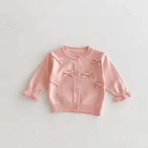 Pink baby girl knit cardigan detail, cute bows decoration and sweet ruffled cuffs design.