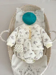 Detailed shot of cute baby girl floral quilted jacket set with lace collar and matching pearl bag.