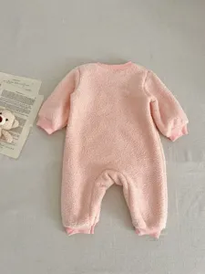 Pink fuzzy baby romper detail, soft fleece long sleeve onesie for infant winter warmth.