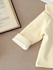 Close-up of baby winter warm top sleeve detail, soft fleece-lined fabric, cute baby clothing.