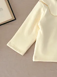 Baby girl light yellow long sleeve top detail, soft fabric, cute peter pan collar design.