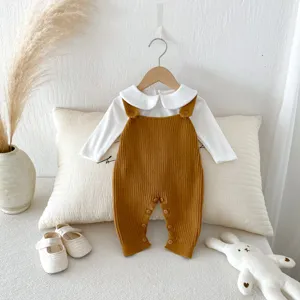 Infant knitted romper set detail, featuring white long-sleeve top and caramel overalls for babies.