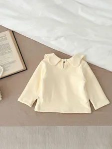 Cozy baby girl long sleeve top in soft yellow with cute collar detail and back button.