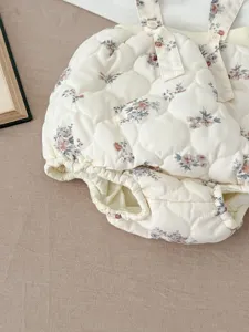 Close-up detail of baby floral quilted rompers featuring cute straps and warm fabric.