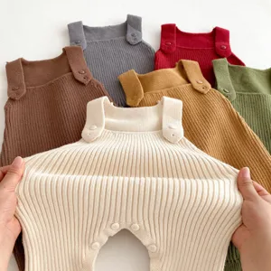 Detail view of baby knit romper details, multiple colors available, soft wool material texture.