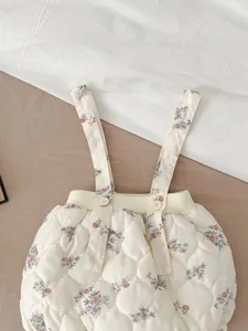 Winter baby girl floral quilted suspender bloomers detail, cozy warm infant outerwear clothing.